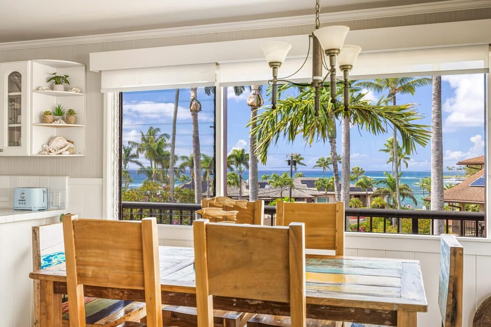 Savor meals at your rustic dining table while tropical breezes flow through open windows, framing stunning ocean views.
