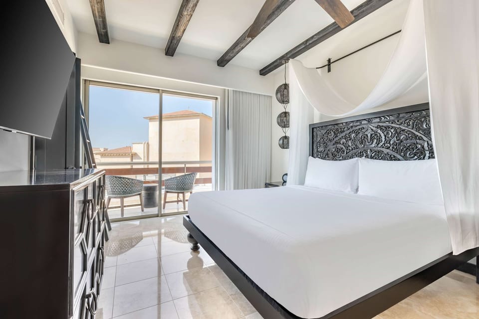 Unwind in a serene king bed with private balcony views.