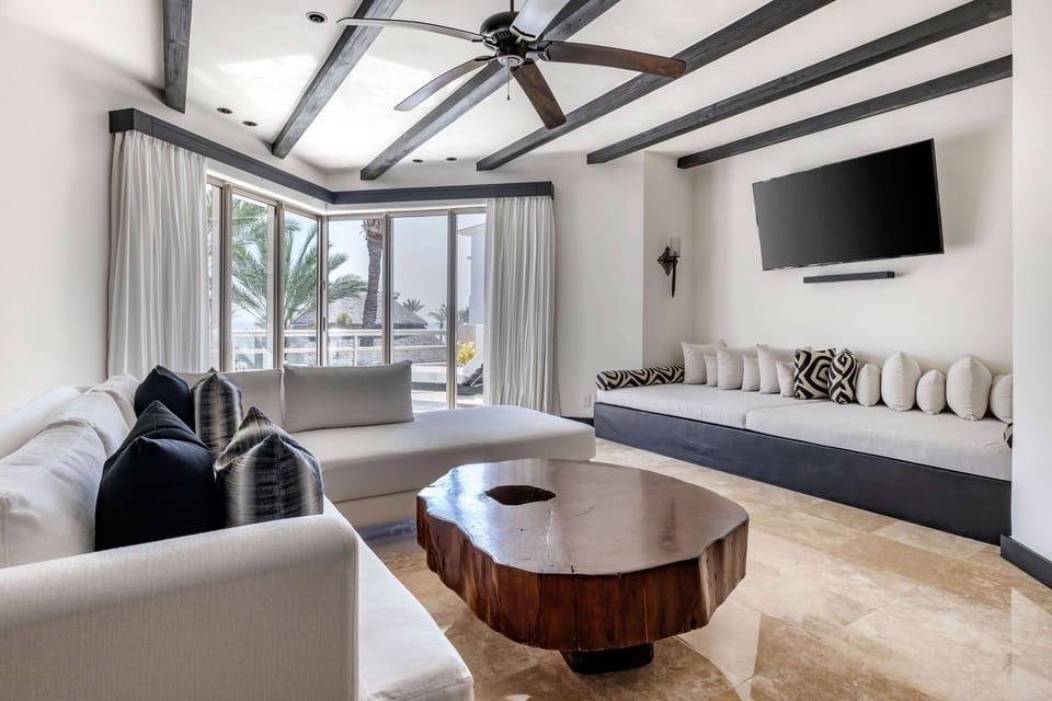 Lounge together in a bright corner seating area by palms.