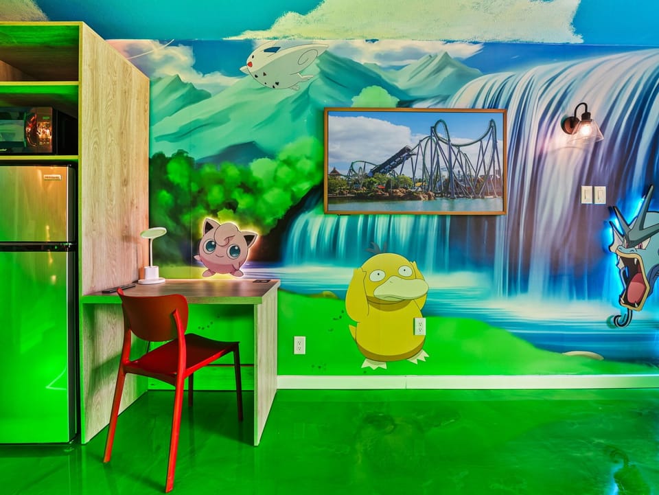 Colorful room featuring a playful mural with popular animated characters and a compact workspace.