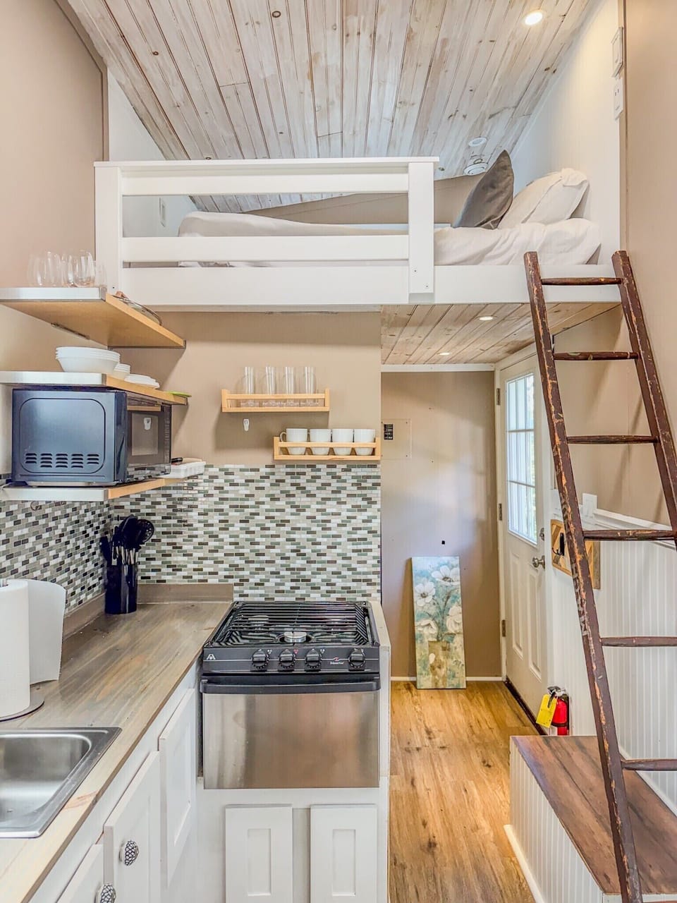 Cozy loft tiny home with stylish kitchenette and warm wood details