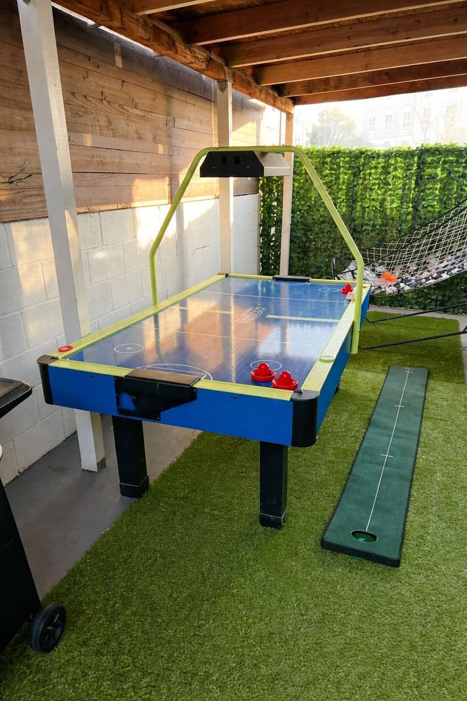 Covered patio with air hockey and games for outdoor fun.