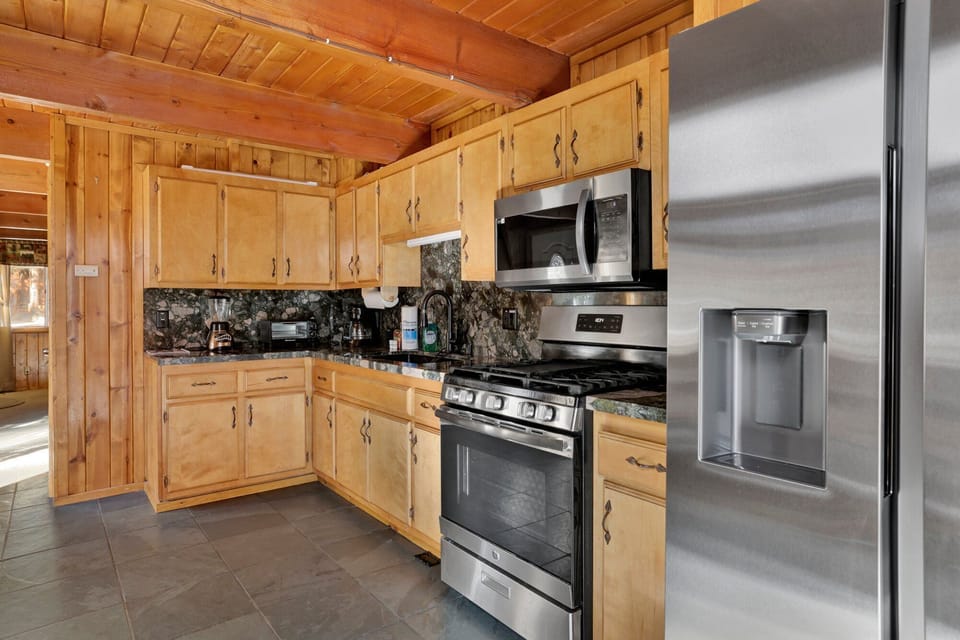 Fully equipped cabin kitchen with ample cabinetry, stove, fridge, microwave, and coffee maker—perfect for cooking meals, morning coffee, and feeling right at home on your stay.