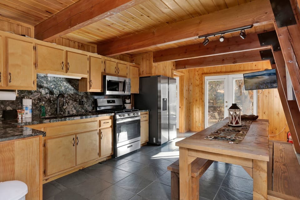 Fully equipped cabin kitchen with ample cabinetry, stove, fridge, microwave, and coffee maker—perfect for cooking meals, morning coffee, and feeling right at home on your stay.