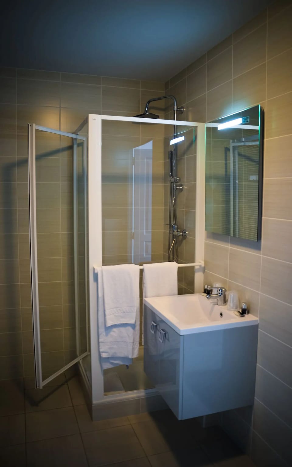 Refresh under the rainfall shower in a sleek, tiled bath.