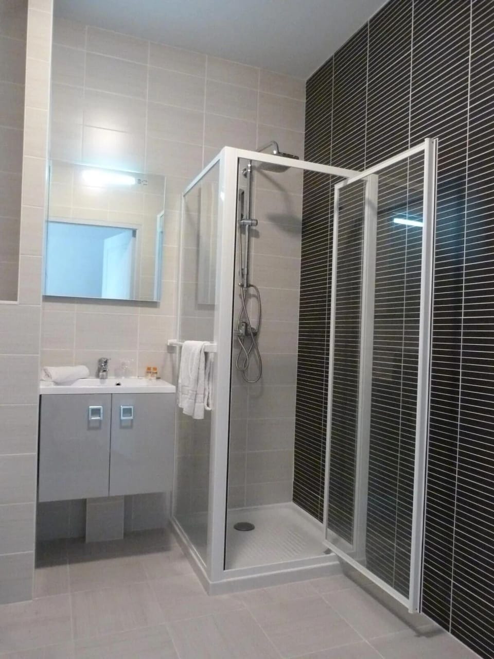 Refresh in a sleek walk-in shower and bright vanity area.