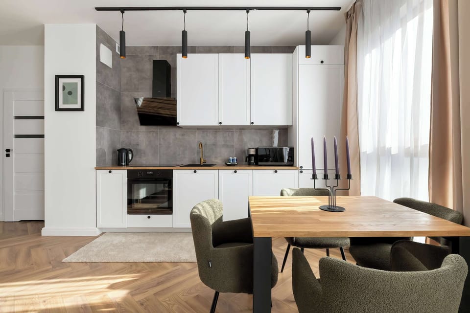 The kitchenette and dining space highlighting sleek cabinetry and under-cabinet lighting. The design emphasizes clean lines and practicality.