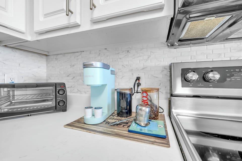 Your mornings start easy with this coffee station, featuring a sleek Keurig and elegant serving tray on polished marble countertops.