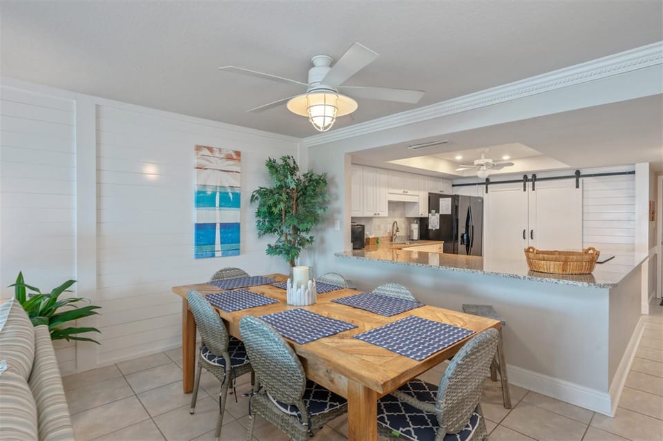 Gather around your stylish dining table for memorable meals together in this open, coastal-themed space with ocean artwork.