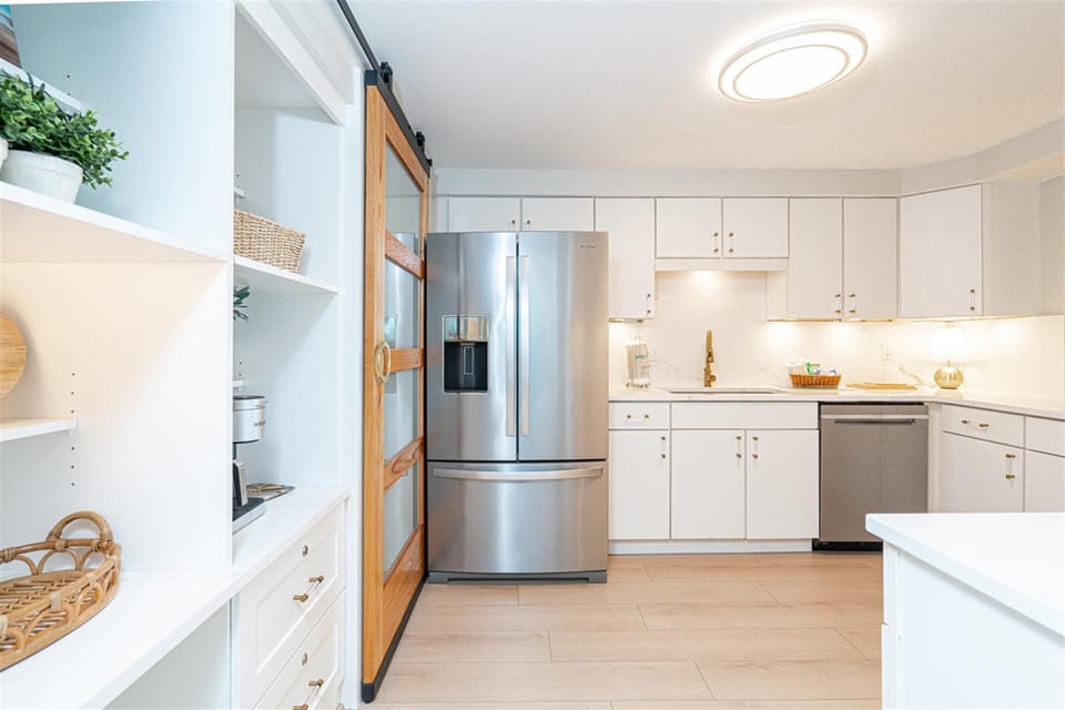 Your spacious kitchen awaits with sleek stainless appliances, pristine white countertops, and thoughtful storage - perfect for cooking memorable meals during your stay.