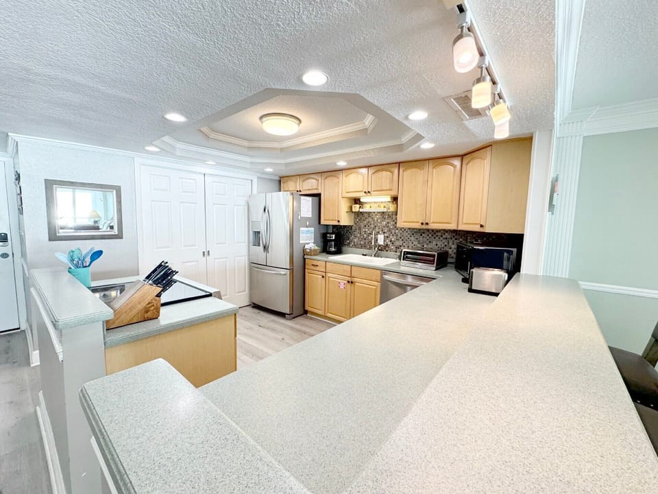 Your fully equipped kitchen invites culinary adventures with granite counters, stainless appliances, and modern track lighting creating the perfect cooking atmosphere.