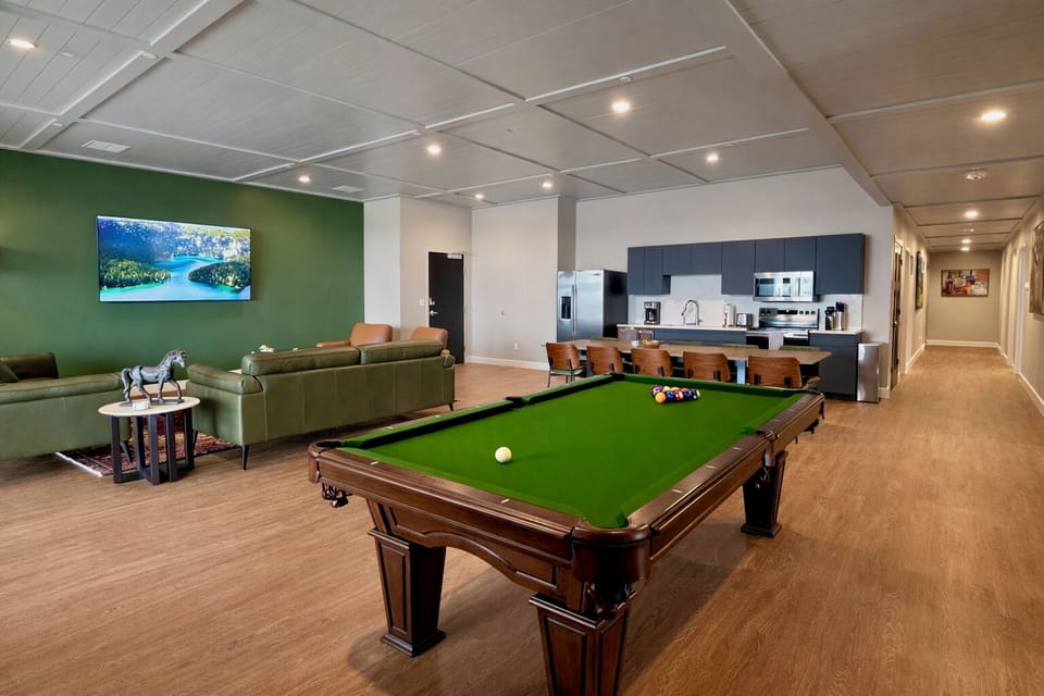 Challenge your friends to a game on the bright green felt pool table right in the massive open living space. A long olive green leather sofa is ready for your whole crew to hang out comfortably.