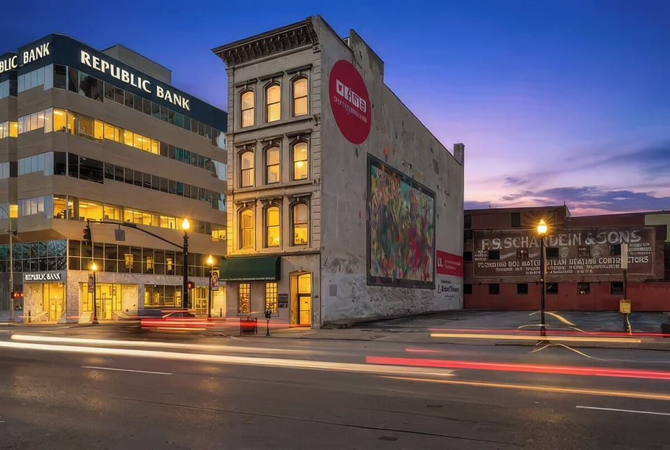 Catch a glimpse of the historic brick exterior illuminated beautifully at twilight. The building stands out on the corner with its classic architecture and mural.