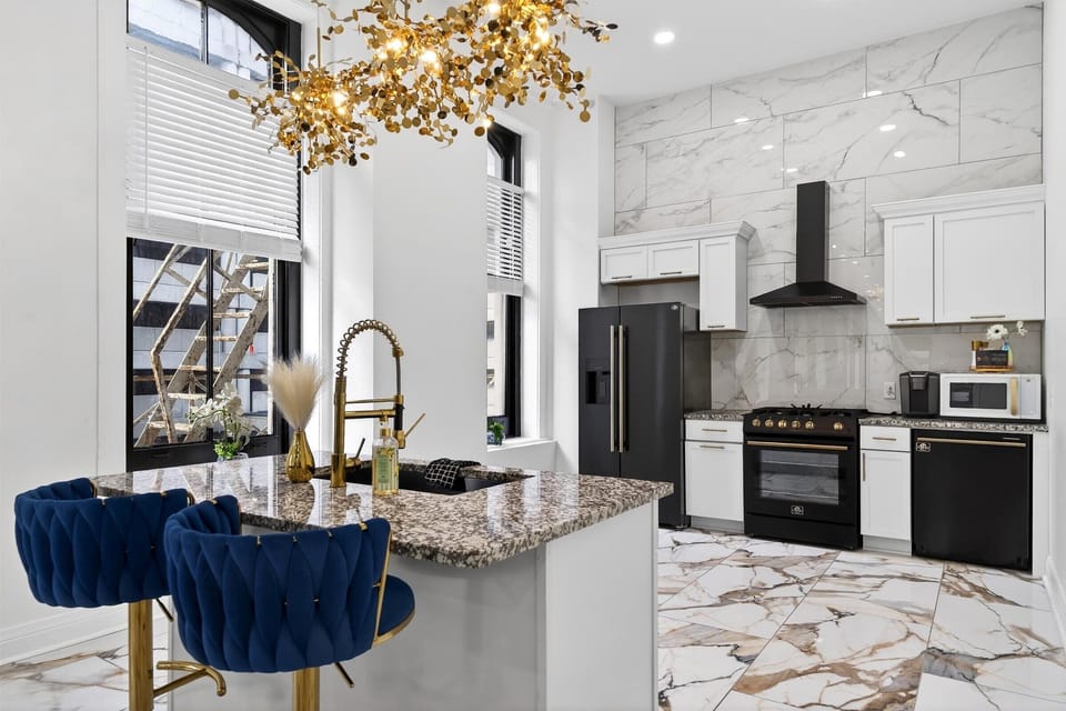 We installed high-end black stainless steel appliances including a gas range and french door fridge. The gold cabinet hardware pops beautifully against the white cupboards.