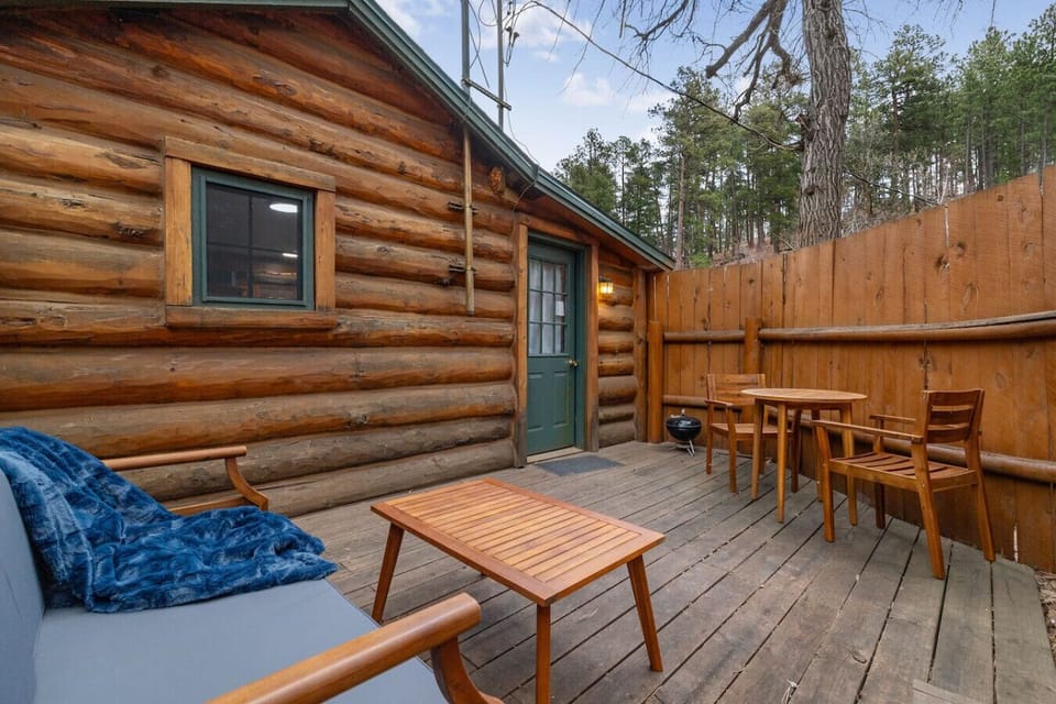 Step into your private cabin with outdoor seating, ideal for relaxing and enjoying the serene forest surroundings.