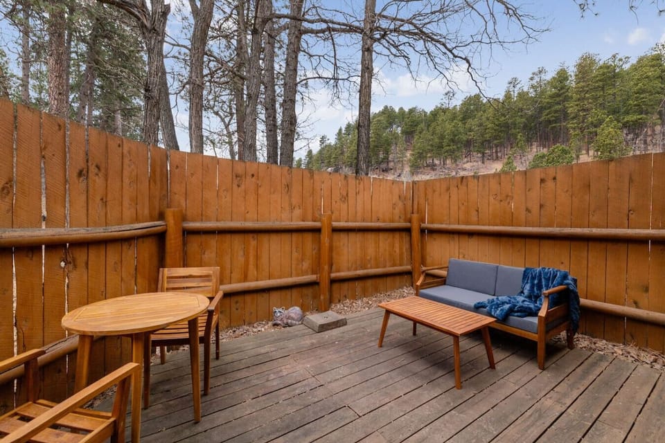 Relax outdoors with cozy chairs and a table, perfect for enjoying the fresh air and peaceful surroundings.