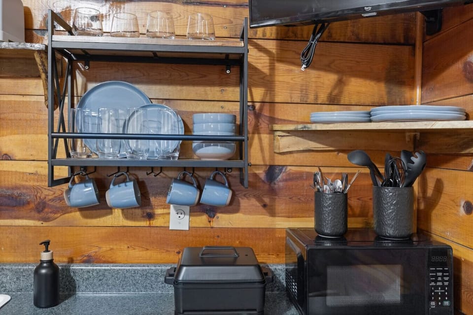 Charming cabin kitchen with a full set of utensils, cookware, and a convenient sink for stress-free cooking.