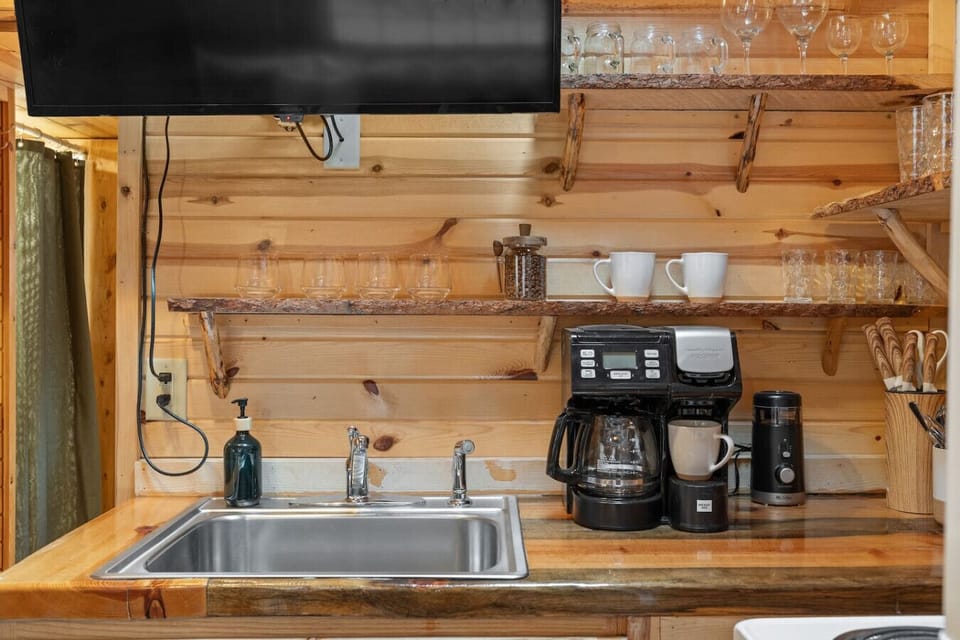 Start your mornings right with a dedicated coffee station, stocked mugs, glassware, and a convenient kitchen sink.