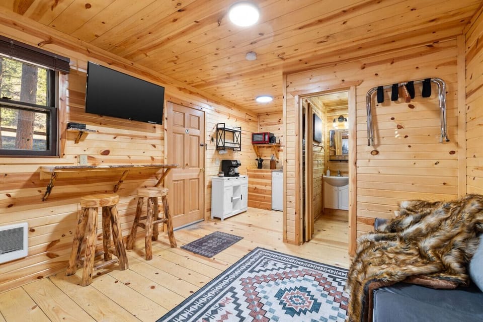 Open and inviting layout with a TV, dining bar, and easy access to the bathroom.
