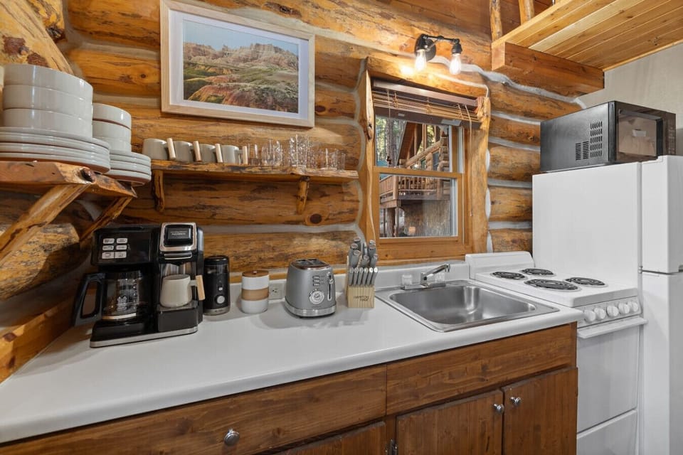 A fully stocked coffee station with grinder, toaster, mugs, and cookware—everything you need for a stress-free Hillside stay.