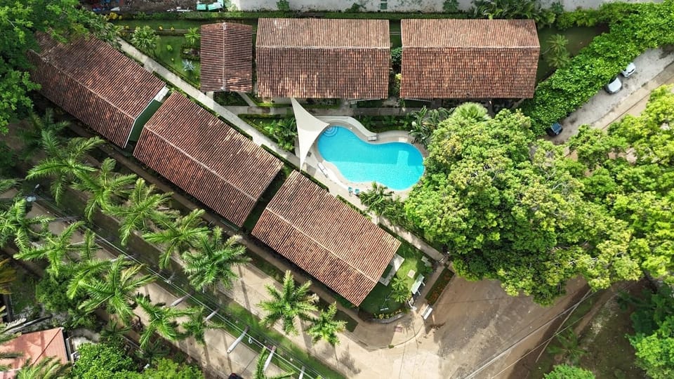 Aerial view of the property showing the pool, tropical gardens, and layout of the complex.