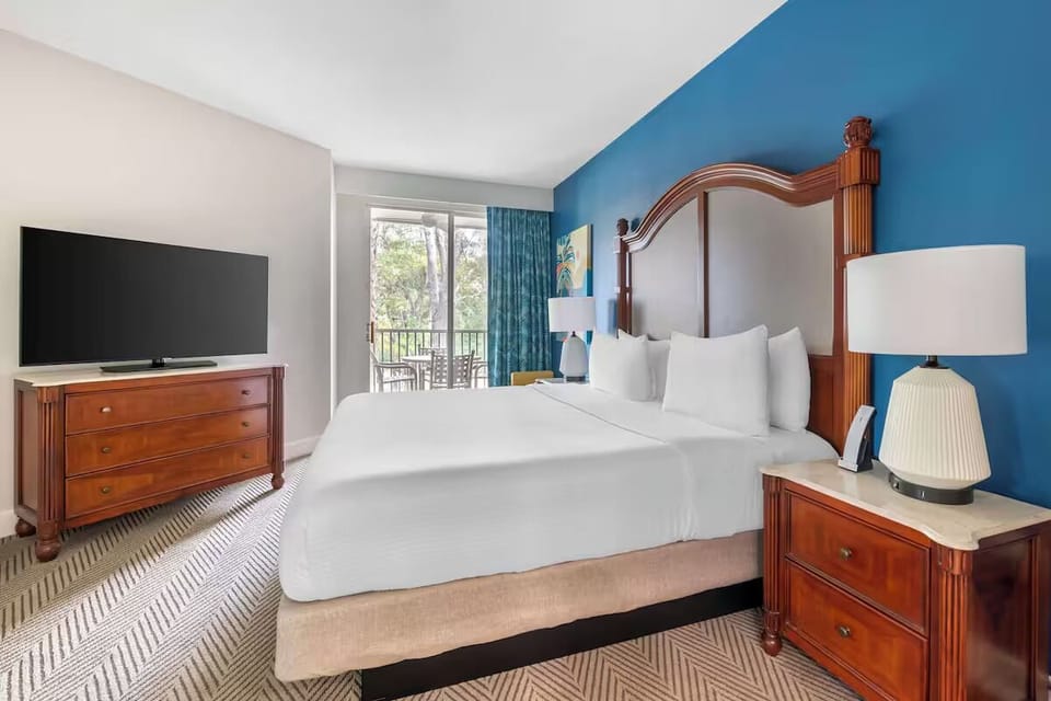 Unwind in a plush king bed with breezy balcony views.