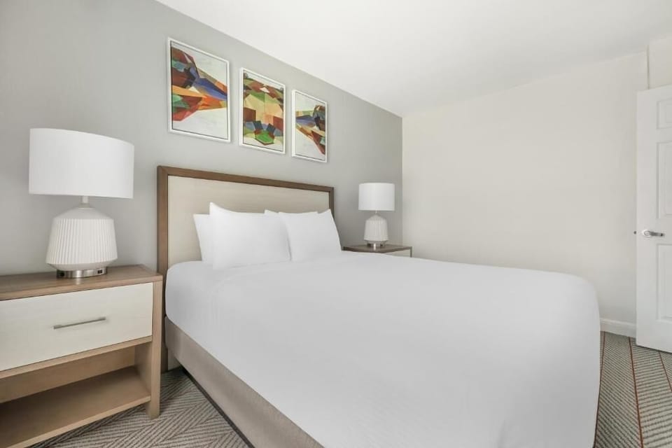 Drift off beneath modern art and warm bedside lighting.