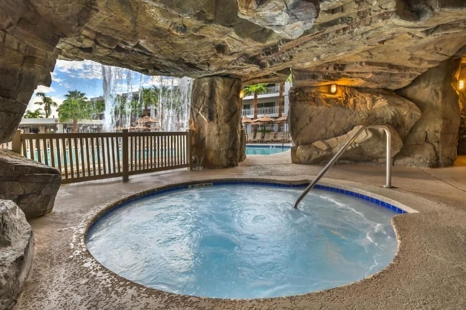 Unwind in a grotto hot tub beneath soothing waterfall sounds.