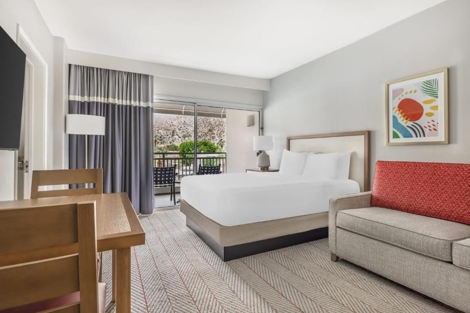 Unwind in a sunlit king bed with balcony views.
