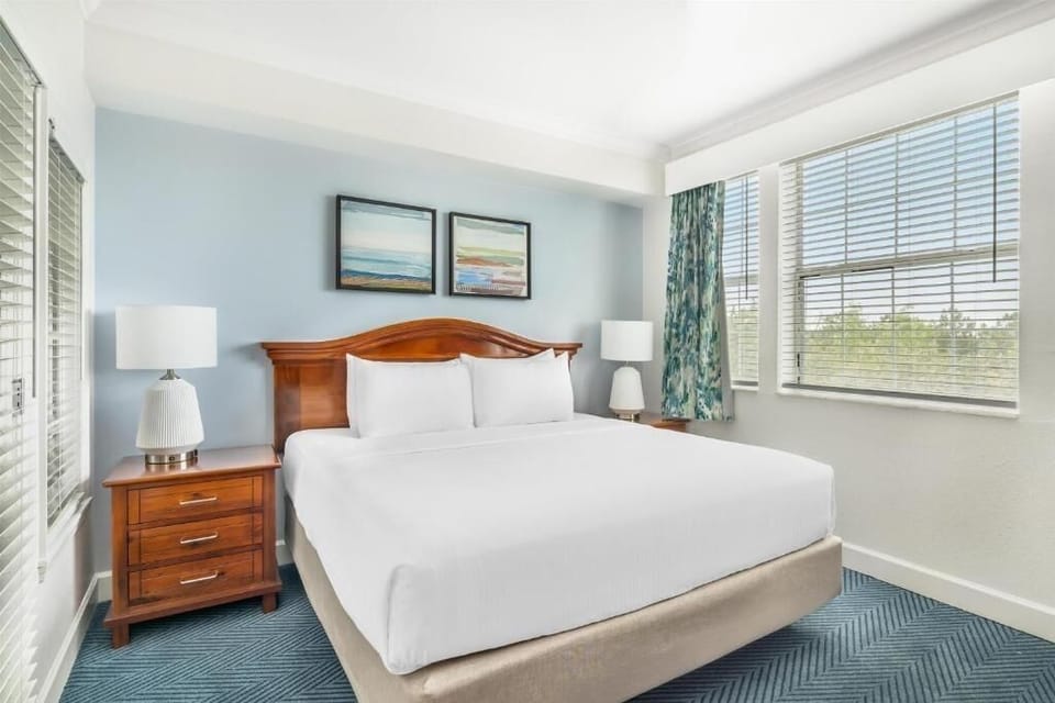 Sink into crisp king comfort beside sunlit windows and calm hues.