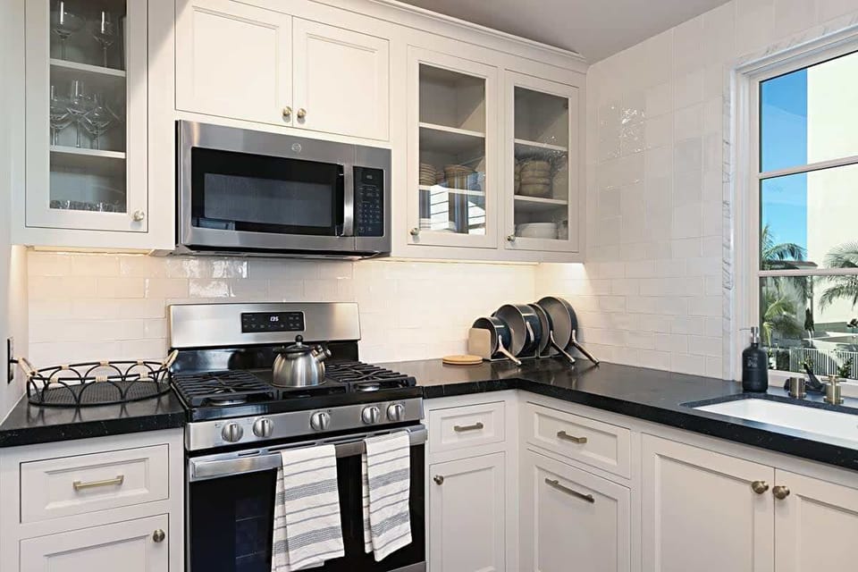 Prepare delicious meals in this fully equipped kitchen, crisp white cabinet, and polished countertops.