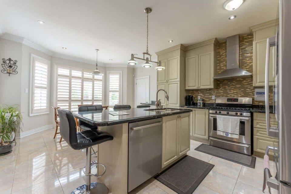 Elevated kitchen with a Centre Island featuring high chairs and a stainless steel Gas Stove complete with an inbuilt Oven, merging style and culinary prowess effortlessly.