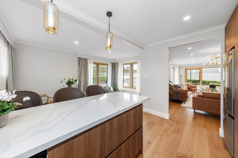 Fully equipped modern kitchen with bar seating (for 3) and dining table (seats 4).