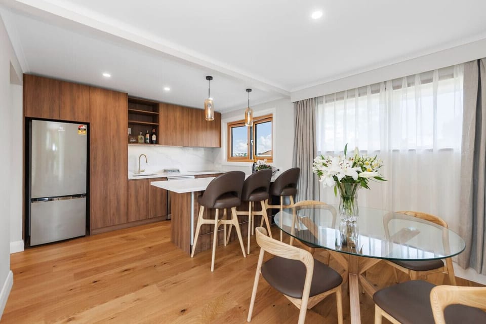 Fully equipped modern kitchen with bar seating (for 3) and dining table (seats 4).
