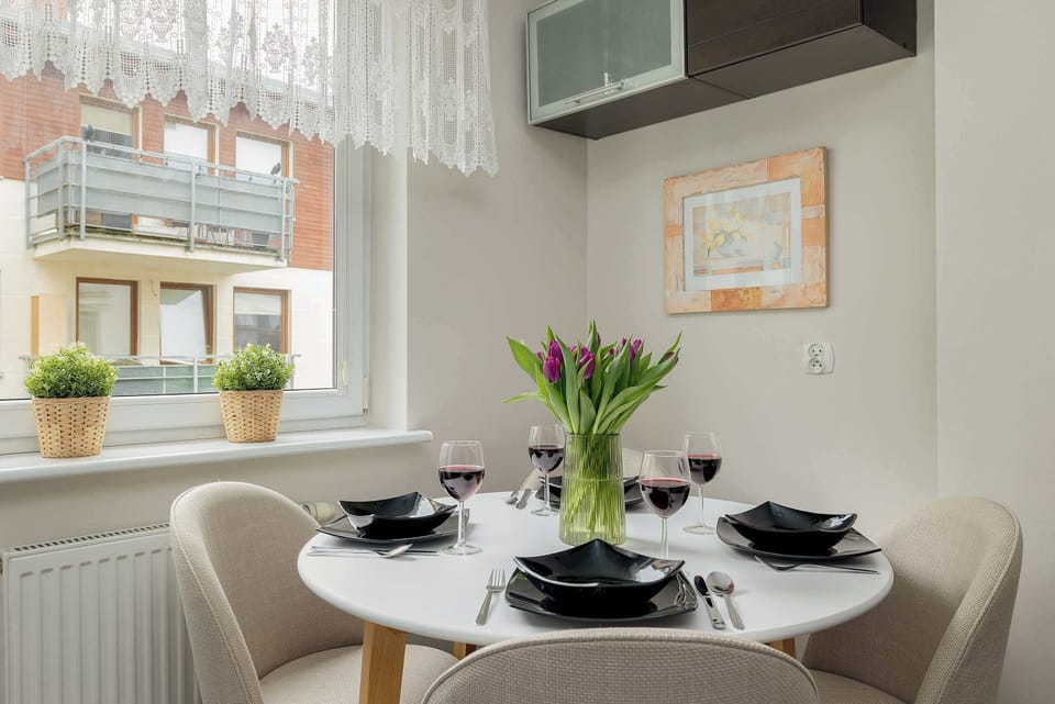 Another view of the dining area highlights the natural light streaming through the window, reflecting off the elegant black dinnerware.