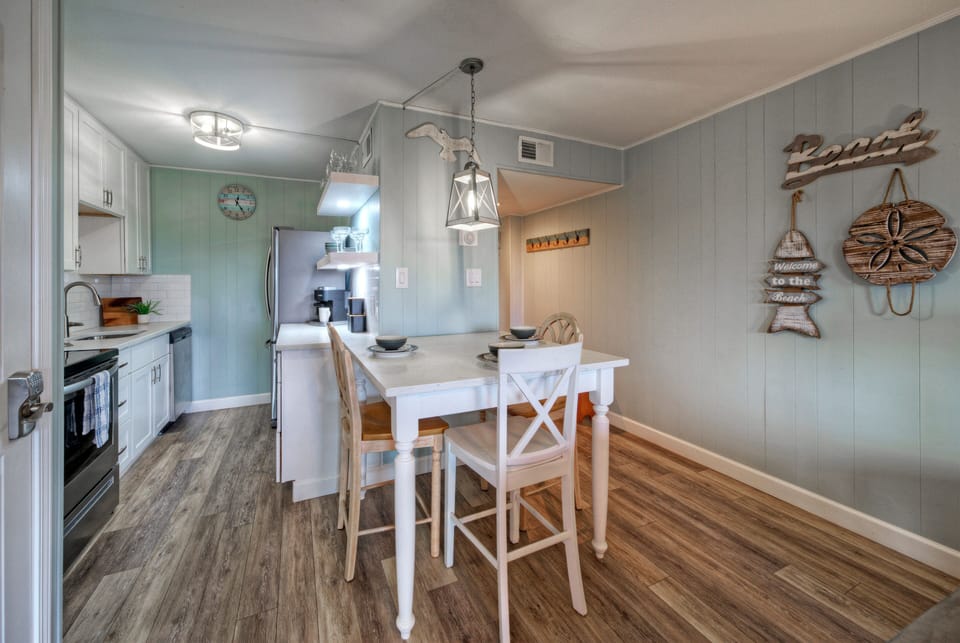 Cozy dining nook and fully equipped kitchen with coastal accents—perfect for easy breakfasts before a day at the beach.