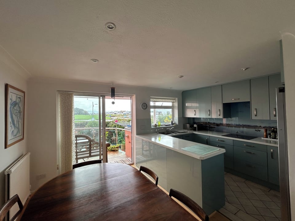 kitchen and dining area with balcony to garden and view