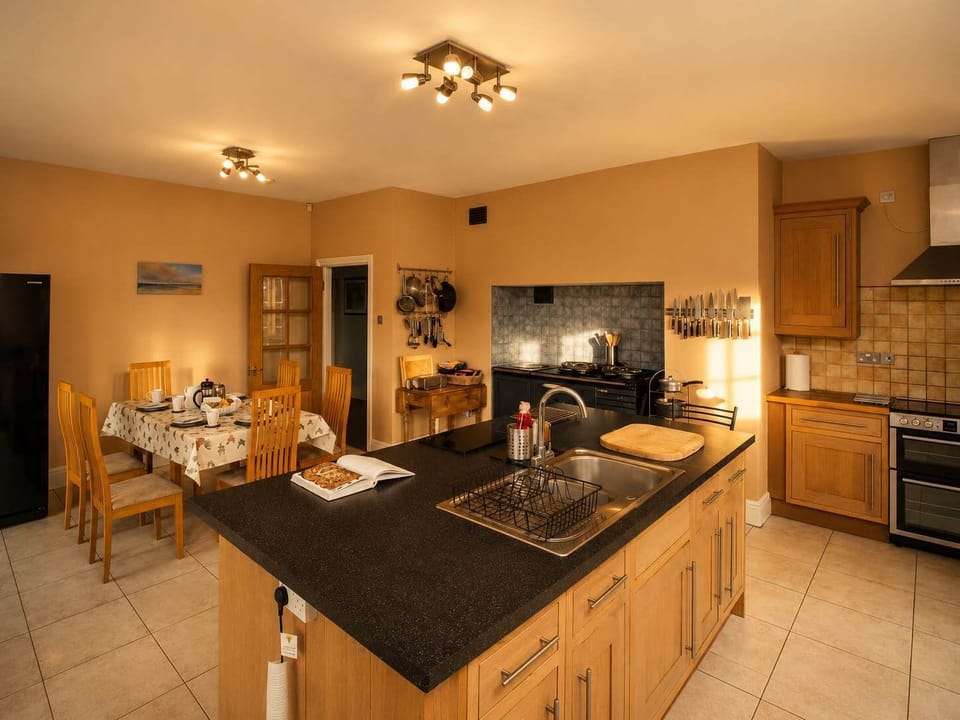Fully equipped kitchen  with 2 ovens including a 4oven electric aga and informal seating  for 6  with French doors to garden