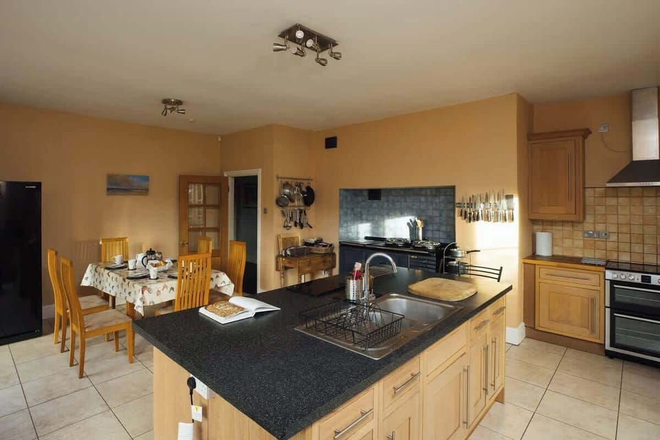 Fully equipped kitchen  with 2 ovens including a 4oven electric aga and informal seating  for 6  with French doors to garden