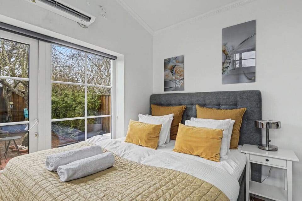 King-size bed with soft natural light and views toward the private fenced terrace. A calm setting designed for two.