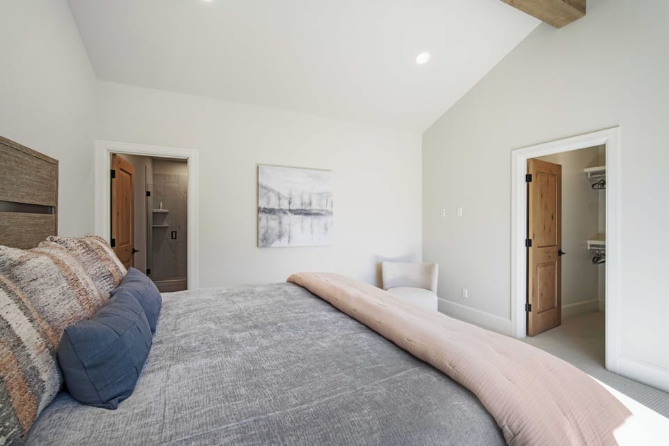 Unwind in your serene retreat featuring soft linens, vaulted ceilings, and a private ensuite for complete relaxation.