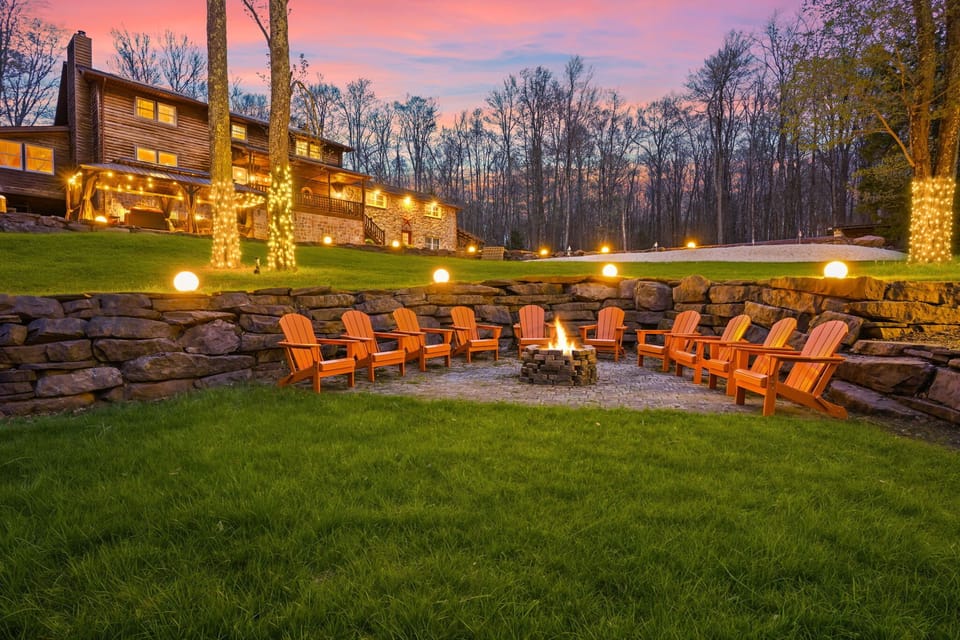 Tiered backyard fire pit area with Adirondack chairs and gorgeous dusk sky