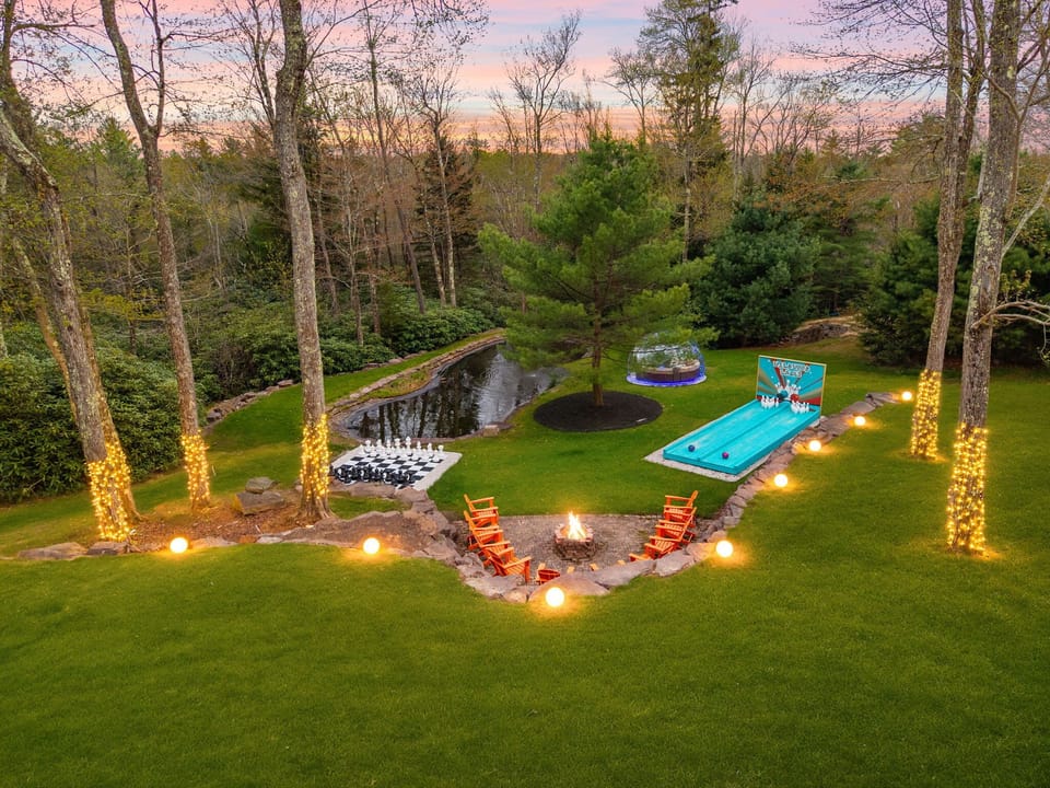 Aerial view of expansive backyard with ping pong, fire pit, and private pond