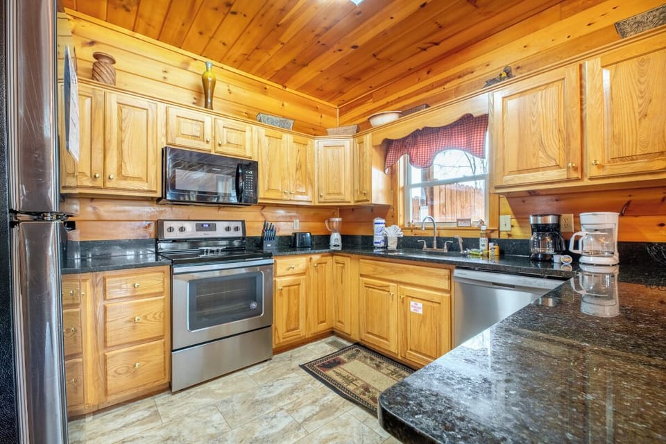 Your fully equipped kitchen features warm wood cabinets, granite counters, and stainless appliances—perfect for preparing memorable meals during your stay.