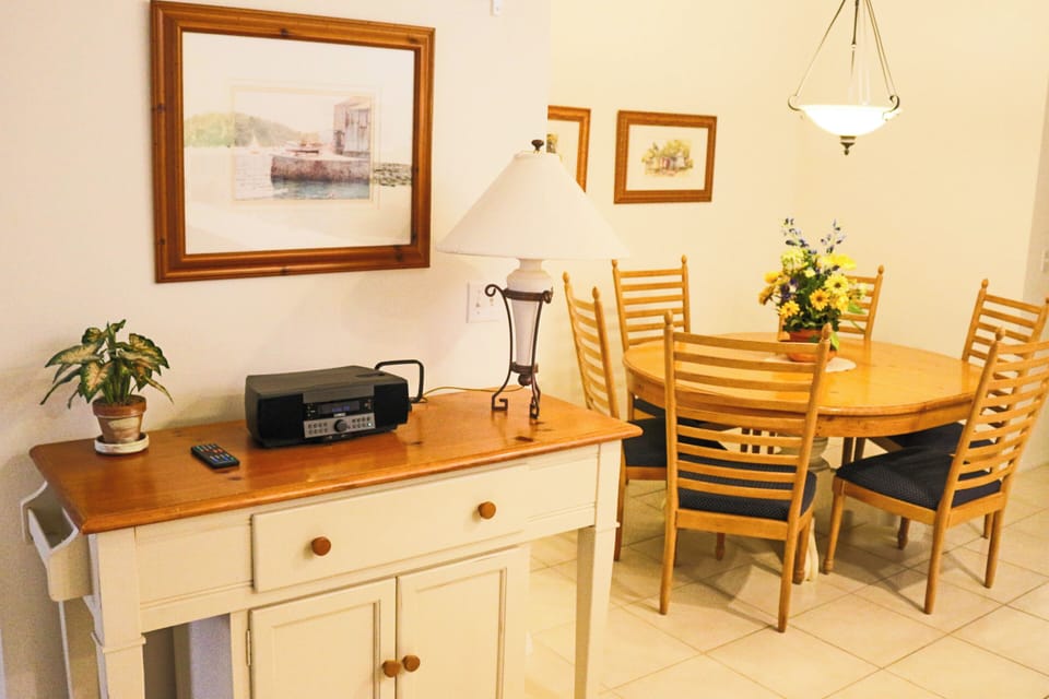 Gather around your warm dining table for memorable meals, with coastal artwork creating a welcoming atmosphere.