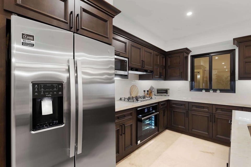 High-end appliances framed by rich custom finishes.