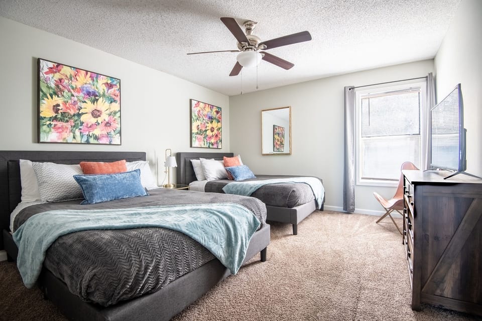 This double-queen bedroom in Unit F is thoughtfully designed with gentle colors and features a smart TV with your favorite streaming apps for your comfort and viewing pleasure!