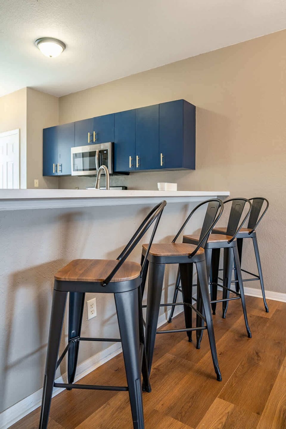 Modern kitchen bar with metal stools and navy cabinets