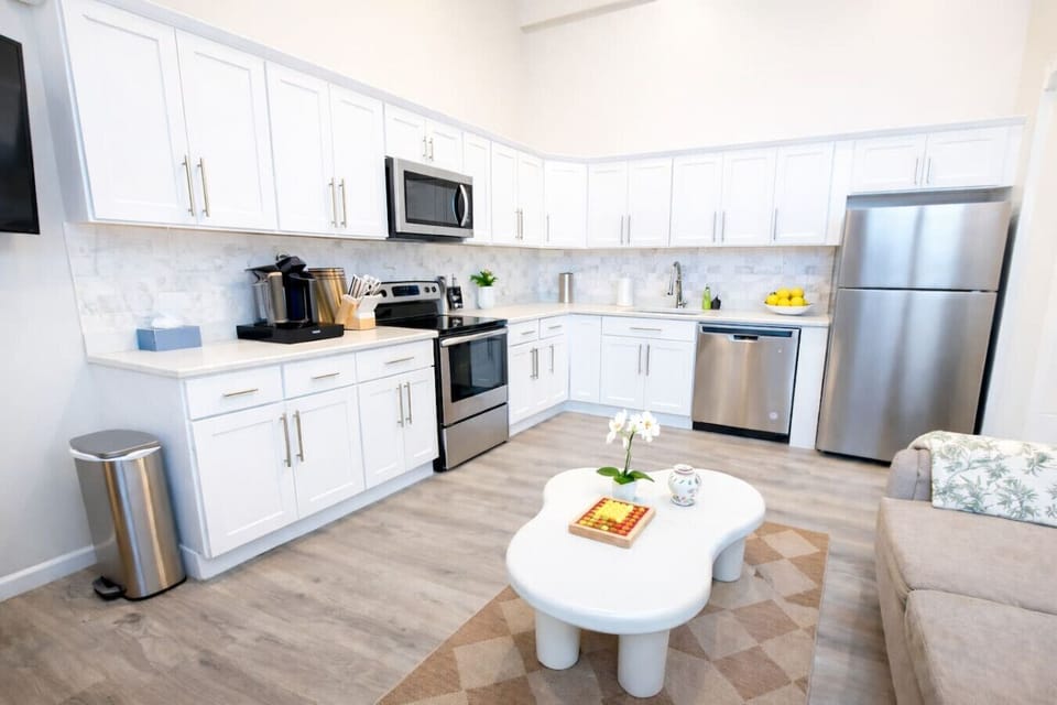Open kitchen and living area with stainless-steel appliances.