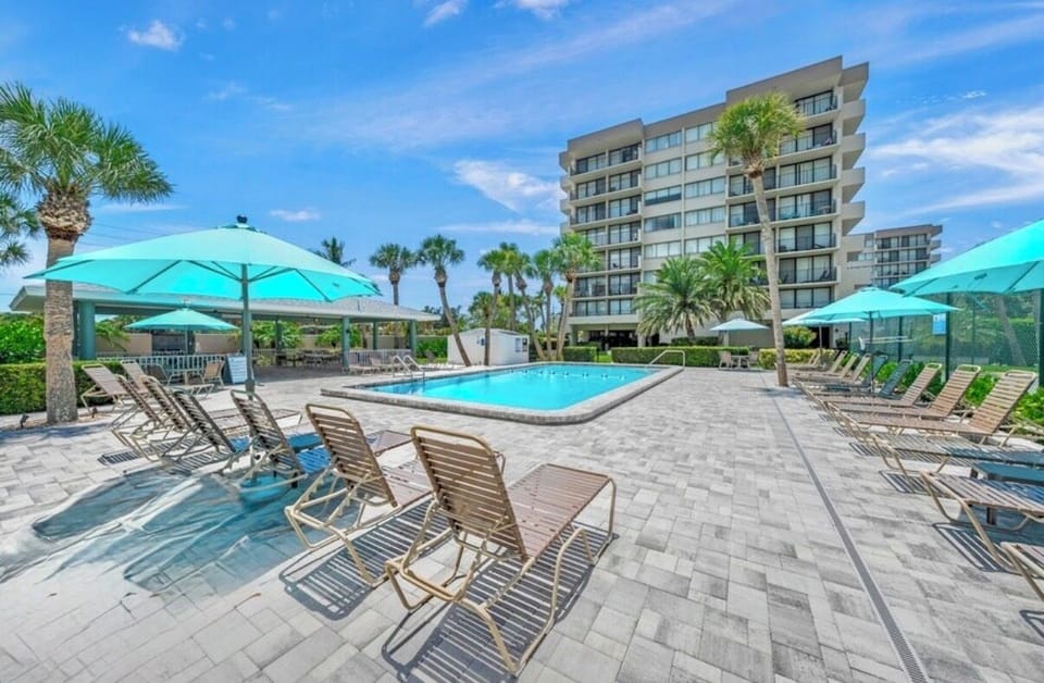 Beautiful pool area with covered pavilion with dining area and gas grills.